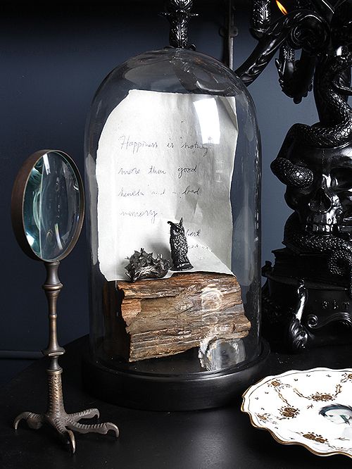 A vintage cloche with wood, a note and some black figurines is always an elegant and cool idea for a vintage Halloween space.