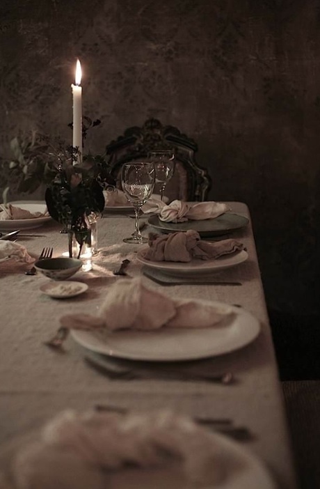 A chic and delicate Halloween wedding table with neutral linens, tall candles and dark blooms and foliage is a very chic solution.