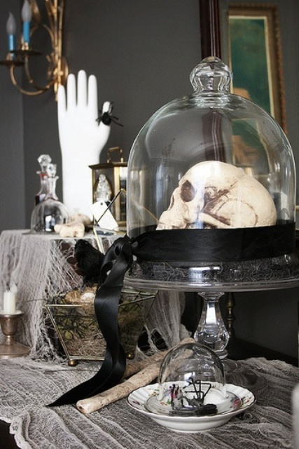 A cloche with a skull on black hay and a black ribbon is a stylish and elegant vintage Halloween decoration to go for.