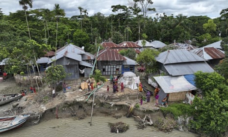 Families live along an eroded embankment by the Meghna River in Bangladesh on 5 July 2022. 