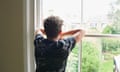 A teenage boy looks out of a window