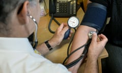 A doctor checking a patient's blood pressure