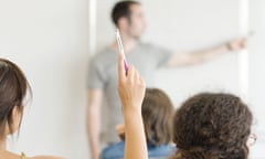 Female student raising hand in class<br>A1F9RB Female student raising hand in class