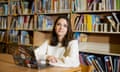 A woman sitting at a laptop in a library.