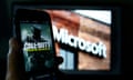 An image from Activision's Call of Duty is shown on a smartphone near a photograph of the Microsoft logo in this photo taken in New York, Thursday, June 15, 2023. A judge handed Microsoft a big victory on Tuesday, declining to stop its $69 billion takeover of video game maker Activision Blizzard.