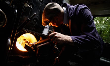 Man shovelling coal into a steam engine