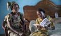 A child reads a book with her mother in their local Wolof language in Senegal.