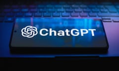 A phone screen displays the ChatGPT logo as it sits on a laptop