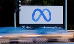 Blurry cars speed in front of a sign for Meta at the California headquarters