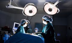 Female nurse and surgeon in scrubs during surgery<br>Royalty-Free Stock Photography by Rubberball