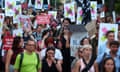 People march through the street holding anti-AfD banners and placards