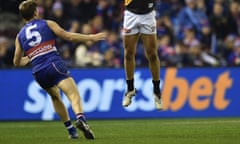 Two AFL players with a Sportsbet advertising banner in the background