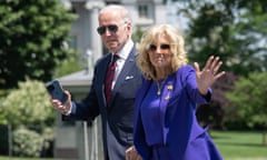 Joe and Jill Biden hold hands as they wave to the camera.