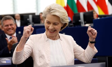 A smiling Ursula von der Leyen raises her clenched fists in the air after winning the vote in the parliamentary chamber