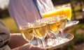 Waiter and waitress serving glasses of wine and orange juice on silver trays at a function<br>C099WX Waiter and waitress serving glasses of wine and orange juice on silver trays at a function