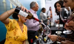 a woman pours wine into wine glasses