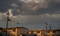 buildings and telephone poles below dark clouds