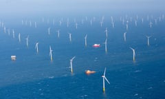 A wide shot of dozens of offshore wind turbines