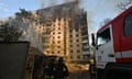 Ukrainian rescuers work to extinguish a fire in a residential building following a missile attack in Kharkiv, Ukraine