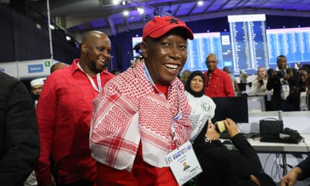 Economic Freedom Fighters (EFF) leader Julius Malema (R) reacts as he arrives to conduct a press conference at the election result centre