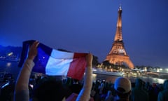 Spectators at the opening ceremony of the Paris 2024 Olympic Games, with the Eiffel Tower in the background.