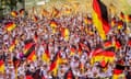 German fans wave their national flag as they march through the streets of Stuttgart towards the stadium to watch the Euro 2024 quarter-final against Spain.