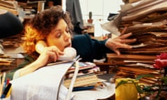 A woman sits at a busy desk