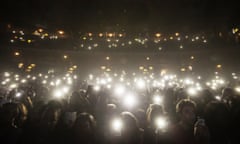 A crowd using their phones as lights