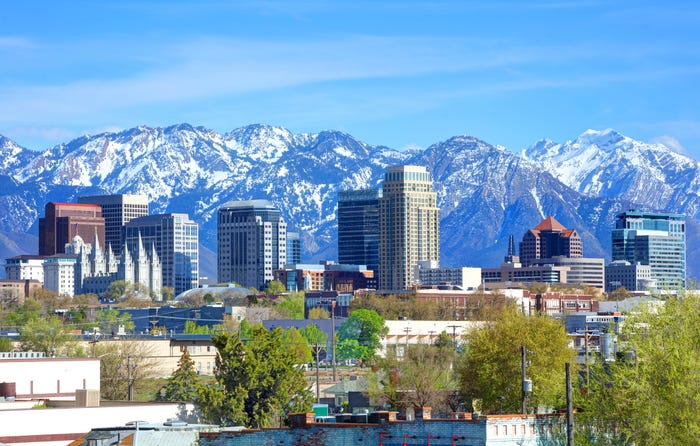 Tall buildings in Salt Lake City with snow-capped mountains behind them.