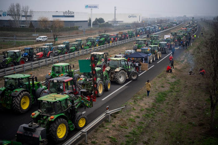 Parked tractors block a highway during a farmers' protest near Mollerussa, northeast Spain, Tuesday, Feb. 6, 2024.