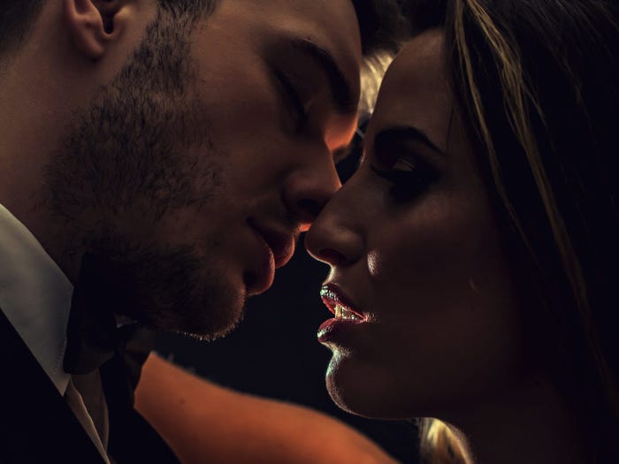 A close up of a couple about to kiss in the dark