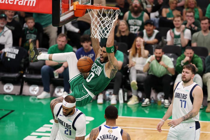 Boston Celtics player Jayson Tatum dunks over Dallas Mavericks players during the 2024 NBA finals.