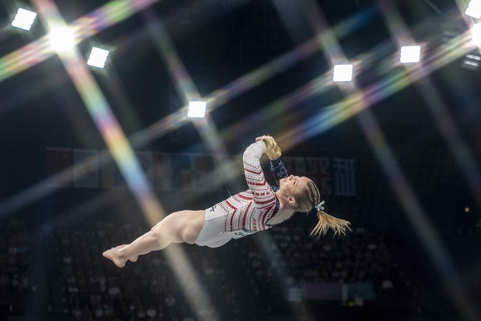 Gymnast Jade Carey twists through the air while a crowd watches during her vault at the 2024 Paris Olympics.