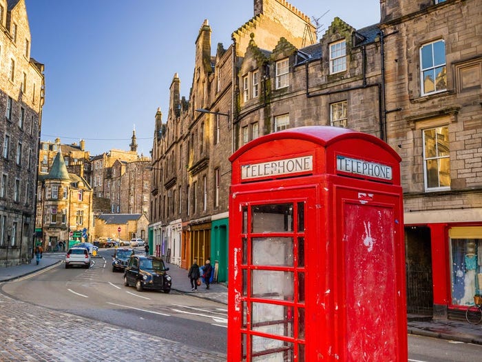 a red phone booth on the royal mile road in scotland