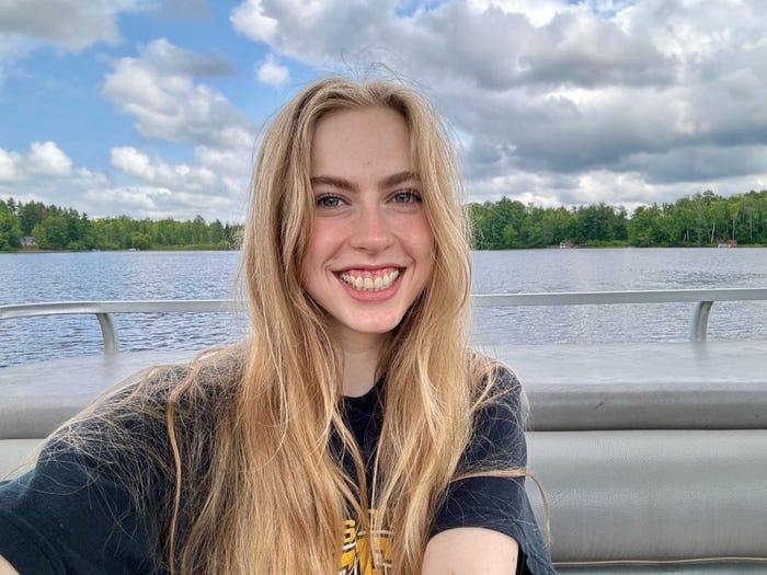 A young woman smiling and taking a selfie on a boat.