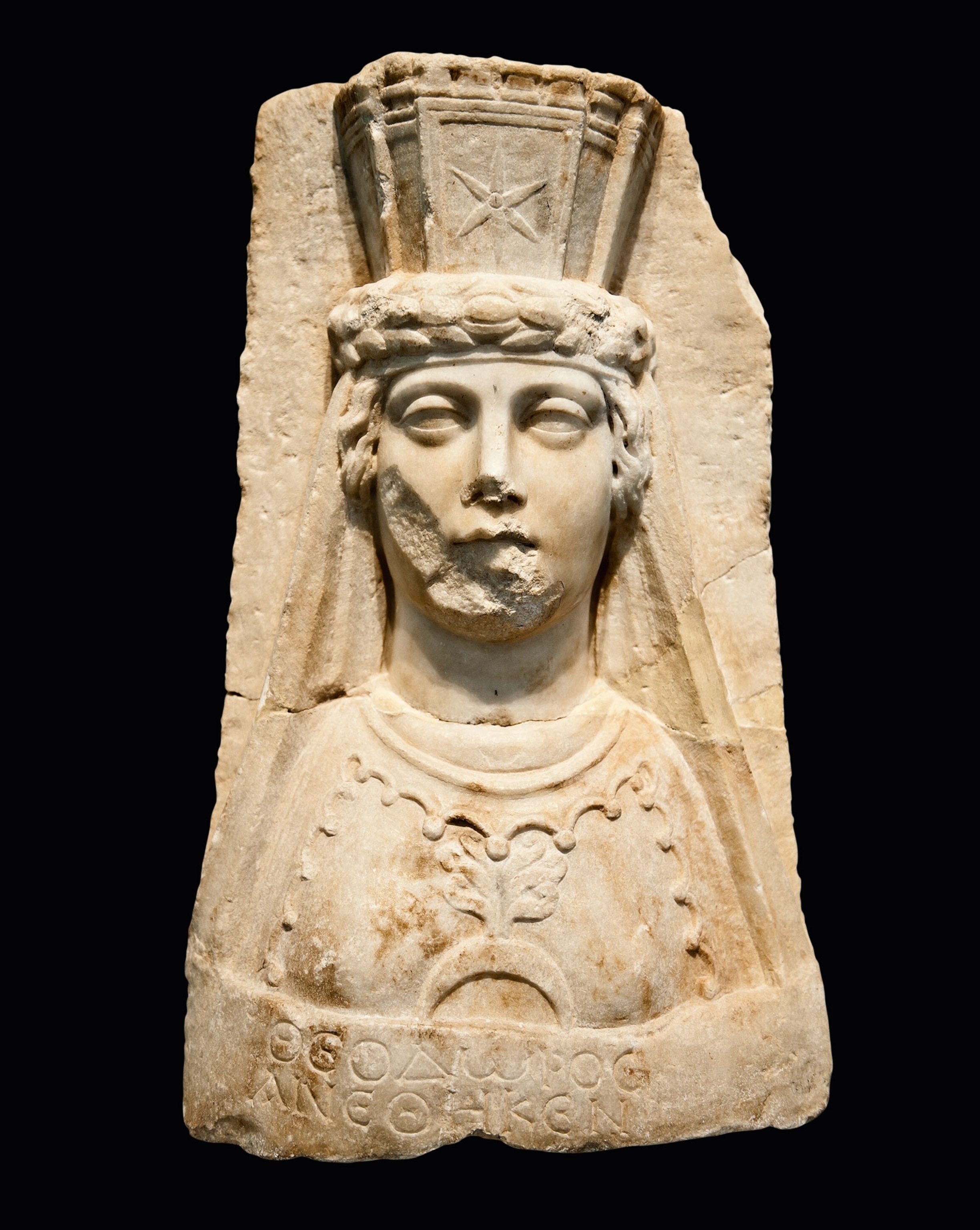 A stone bust of a woman wearing a crown shaped like a basket