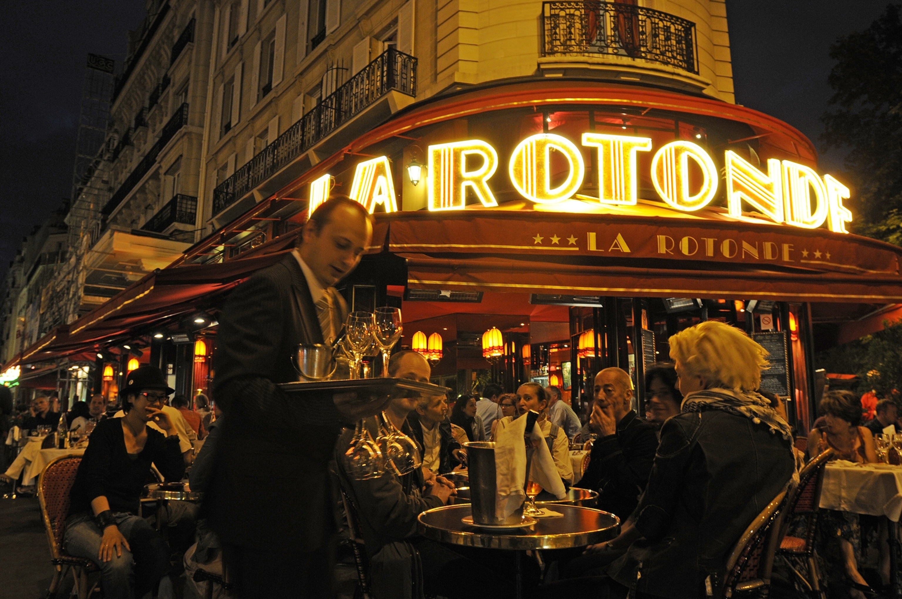 A crowded cafe in Paris at night.