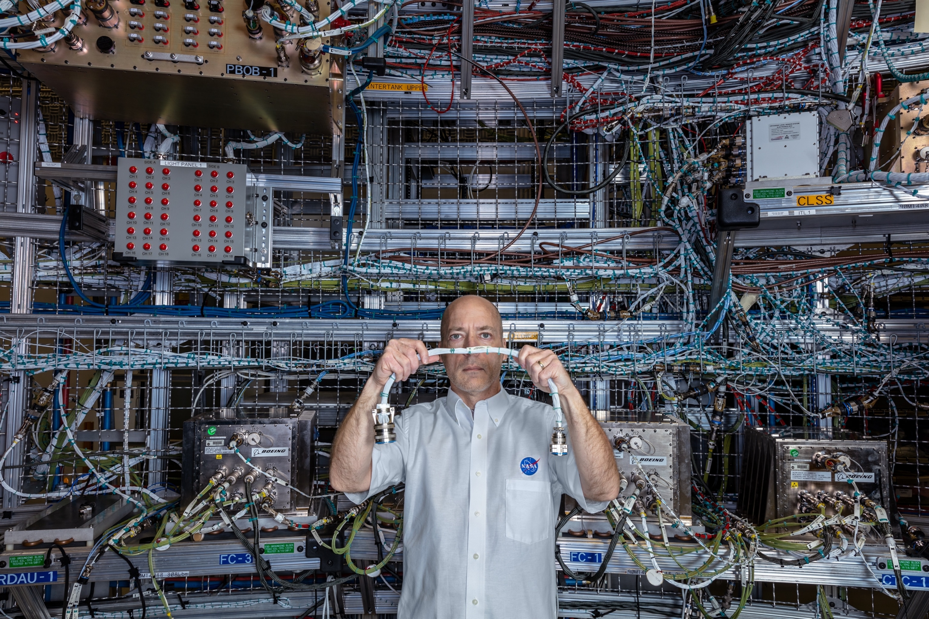 Technician photographed holding connecting cord by Test Stand