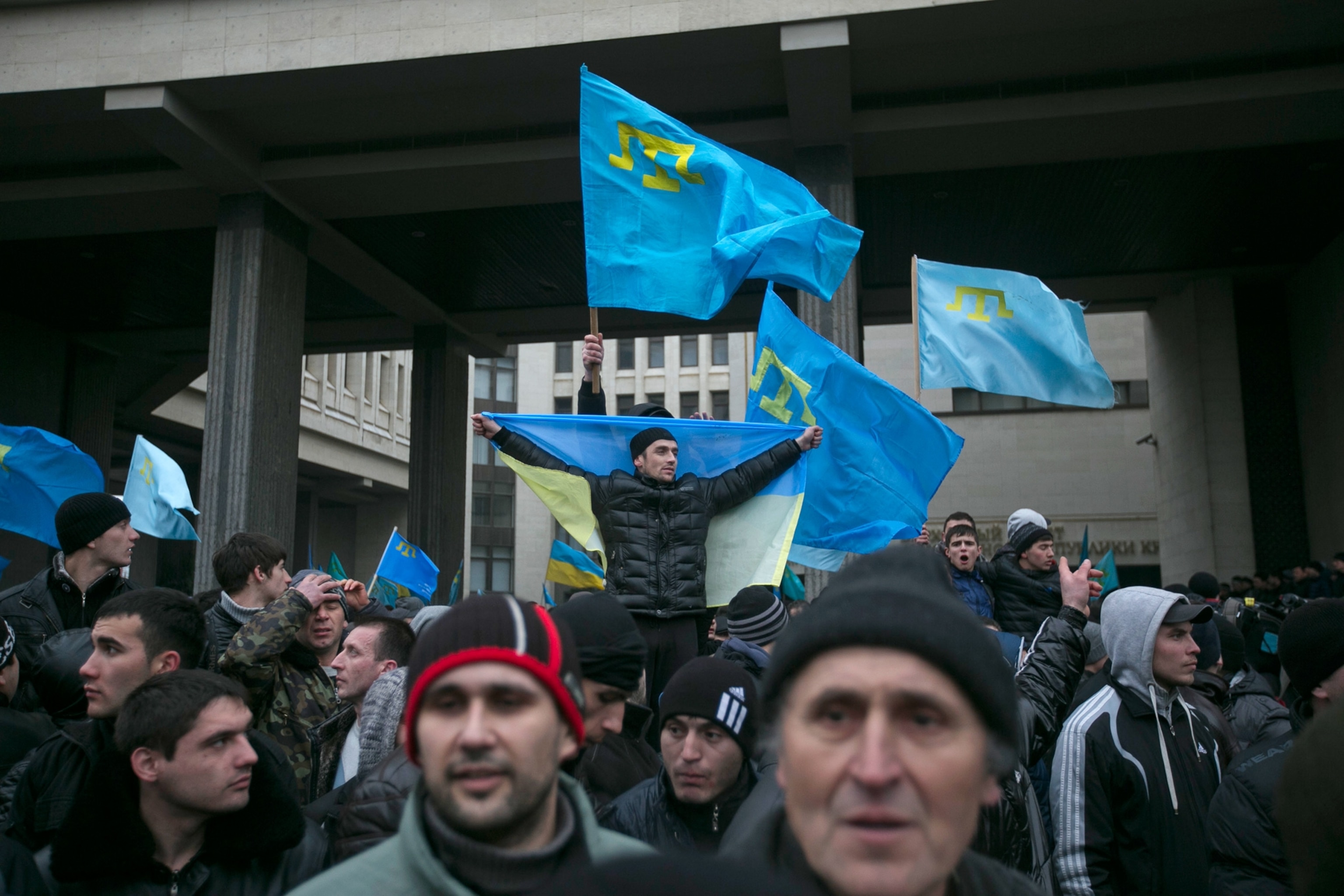 Crimean Tatars holding flags during a rally.