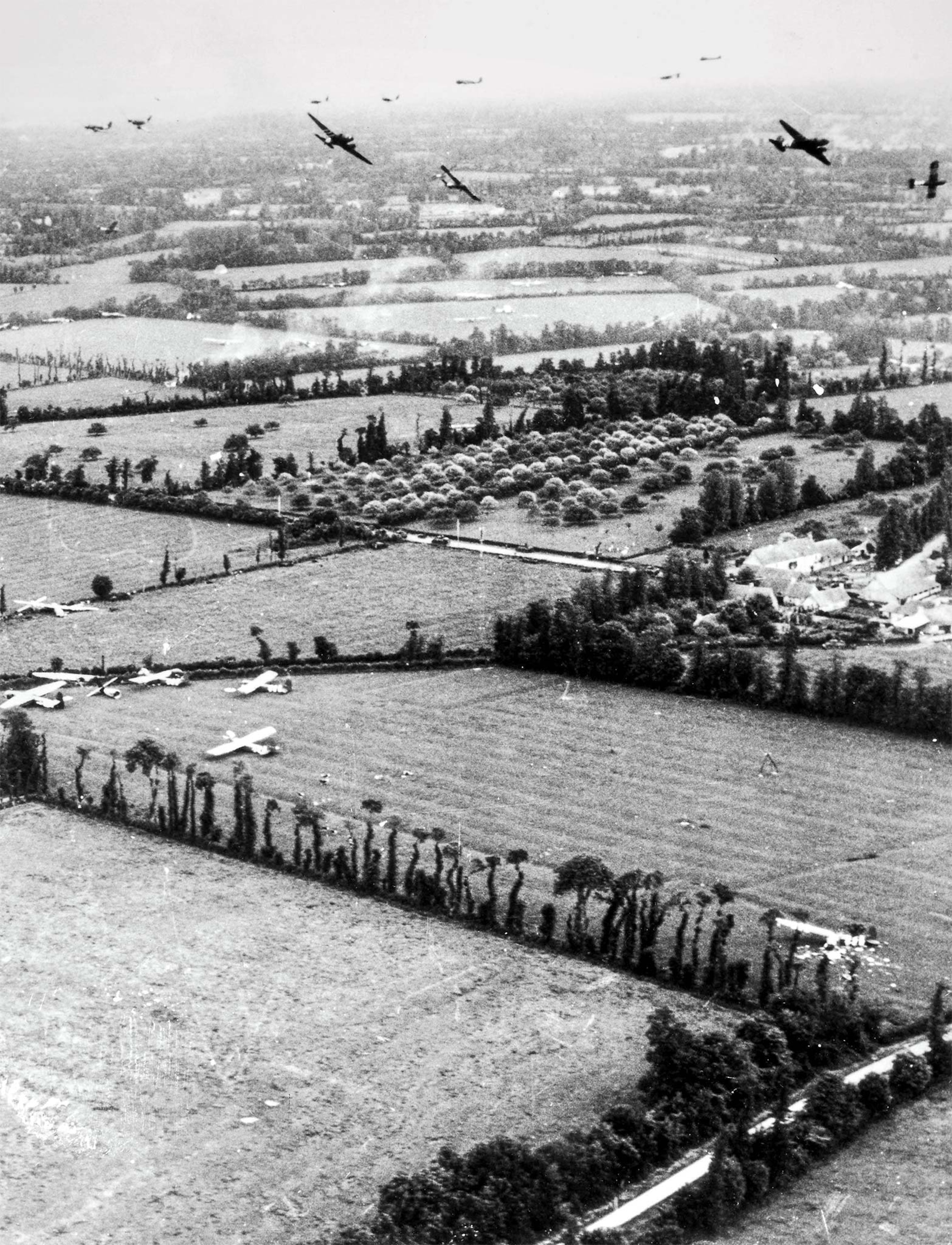 Gliders sit on the ground and fly around in Normandy on the first day of the invasion