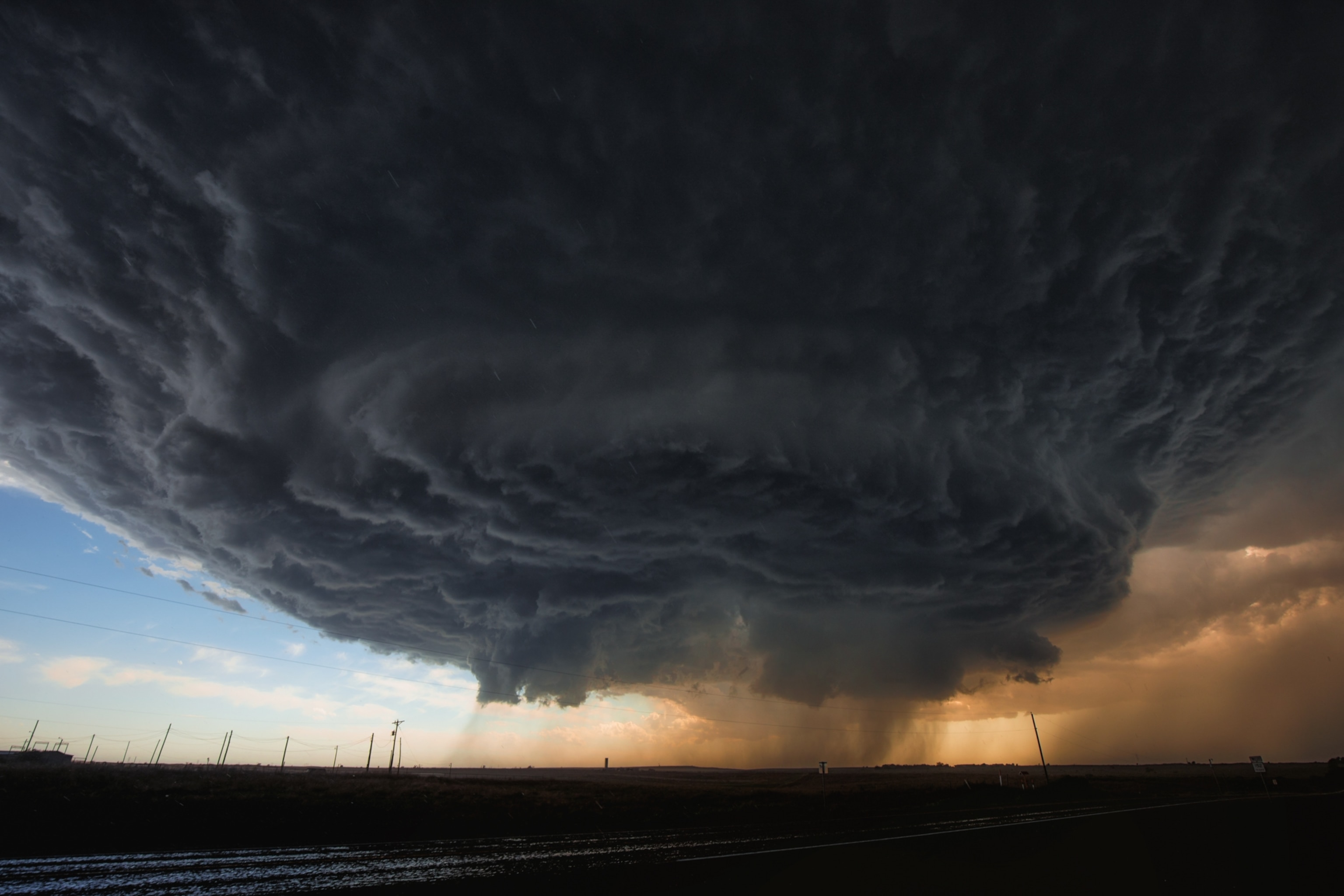 An enormous, dark cloud supercell that appears to be forming a giant funnel.