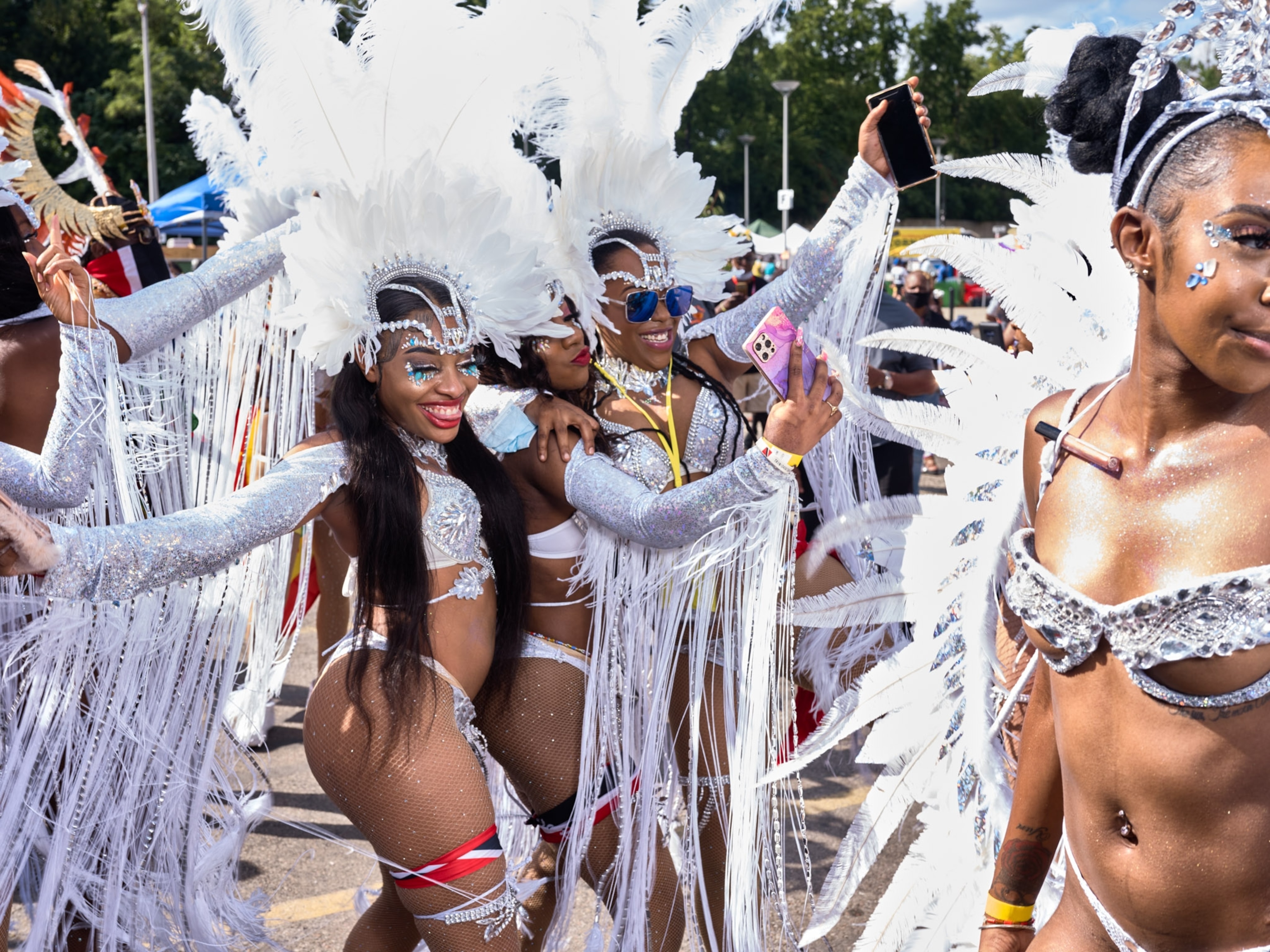 Dances wearing white and silver costumes dance and pose for a picture.