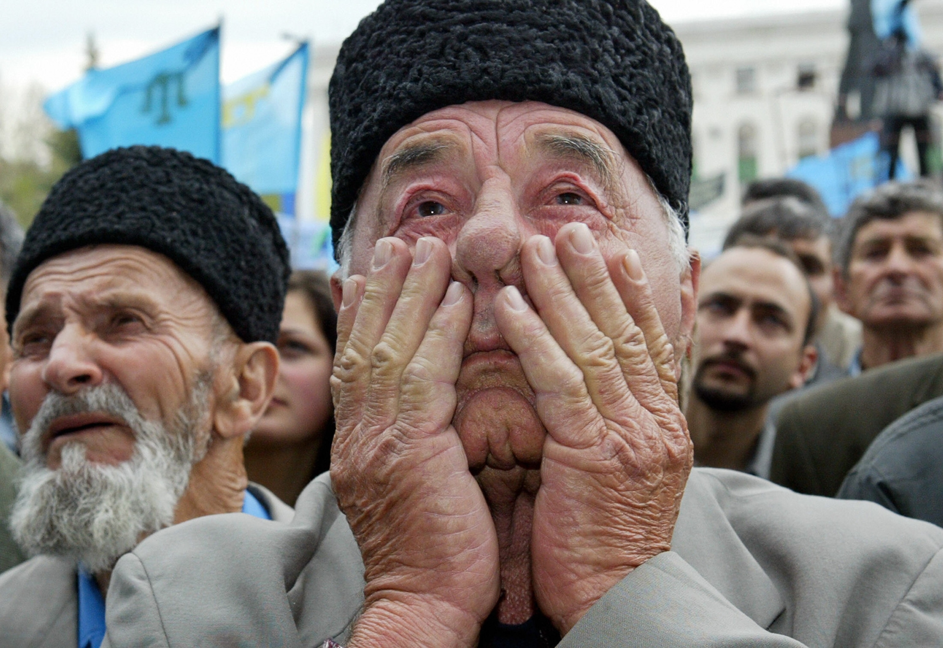 Crimean Tatars holding flags during a rally.