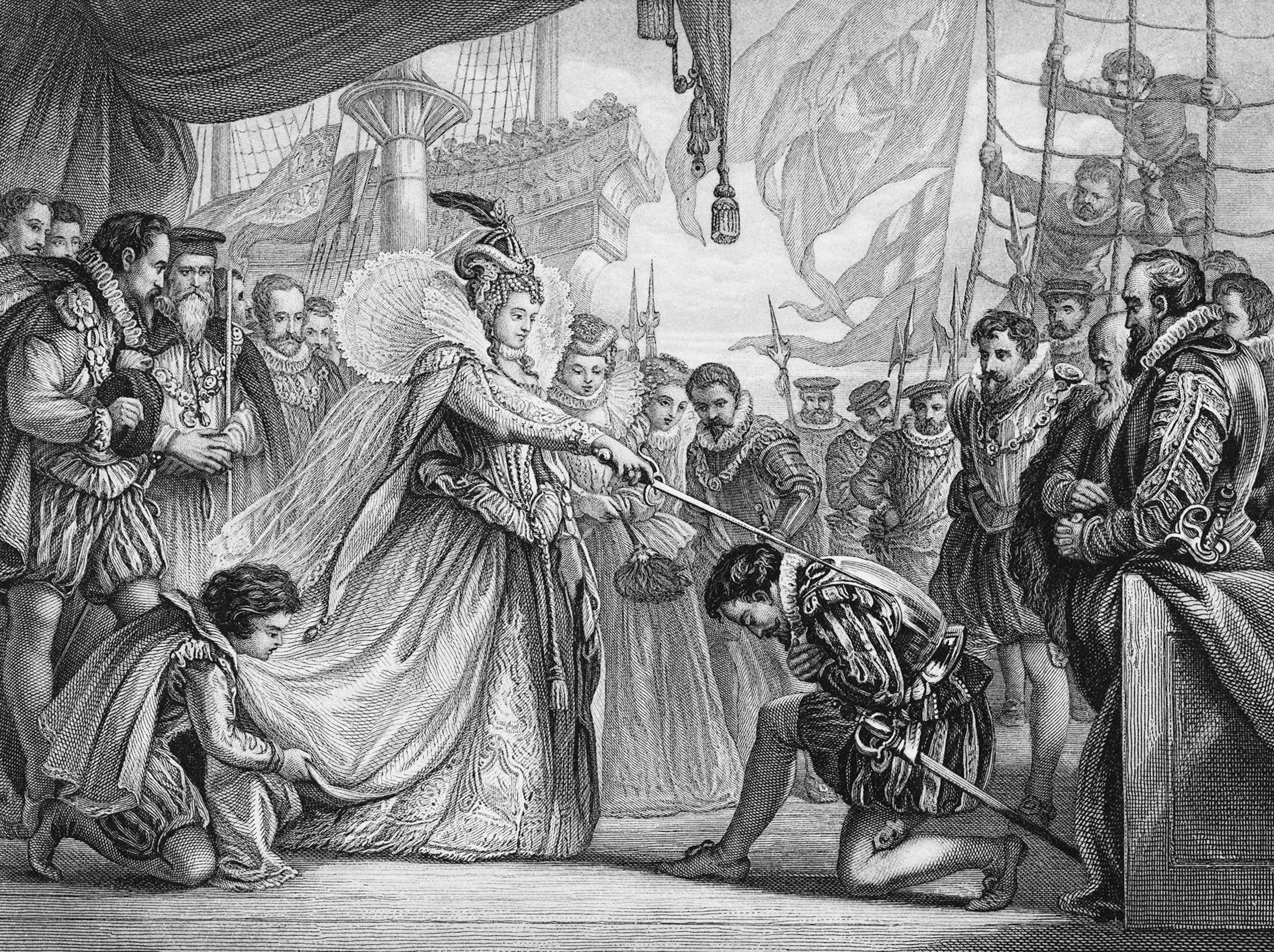 A black and white engraving of Queen Elizabeth, dressed in attire from the 1500s, with a sword resting on the shoulder of a man, kneeling on the ground, also dressed in 1500s attire, with multiple men watching the scene with sails flapping in the background.