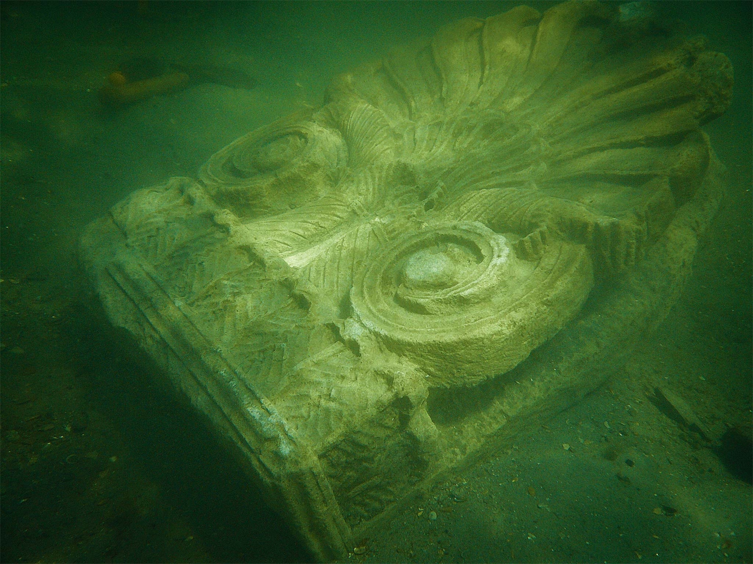 An intricately carved stone tombstone underwater