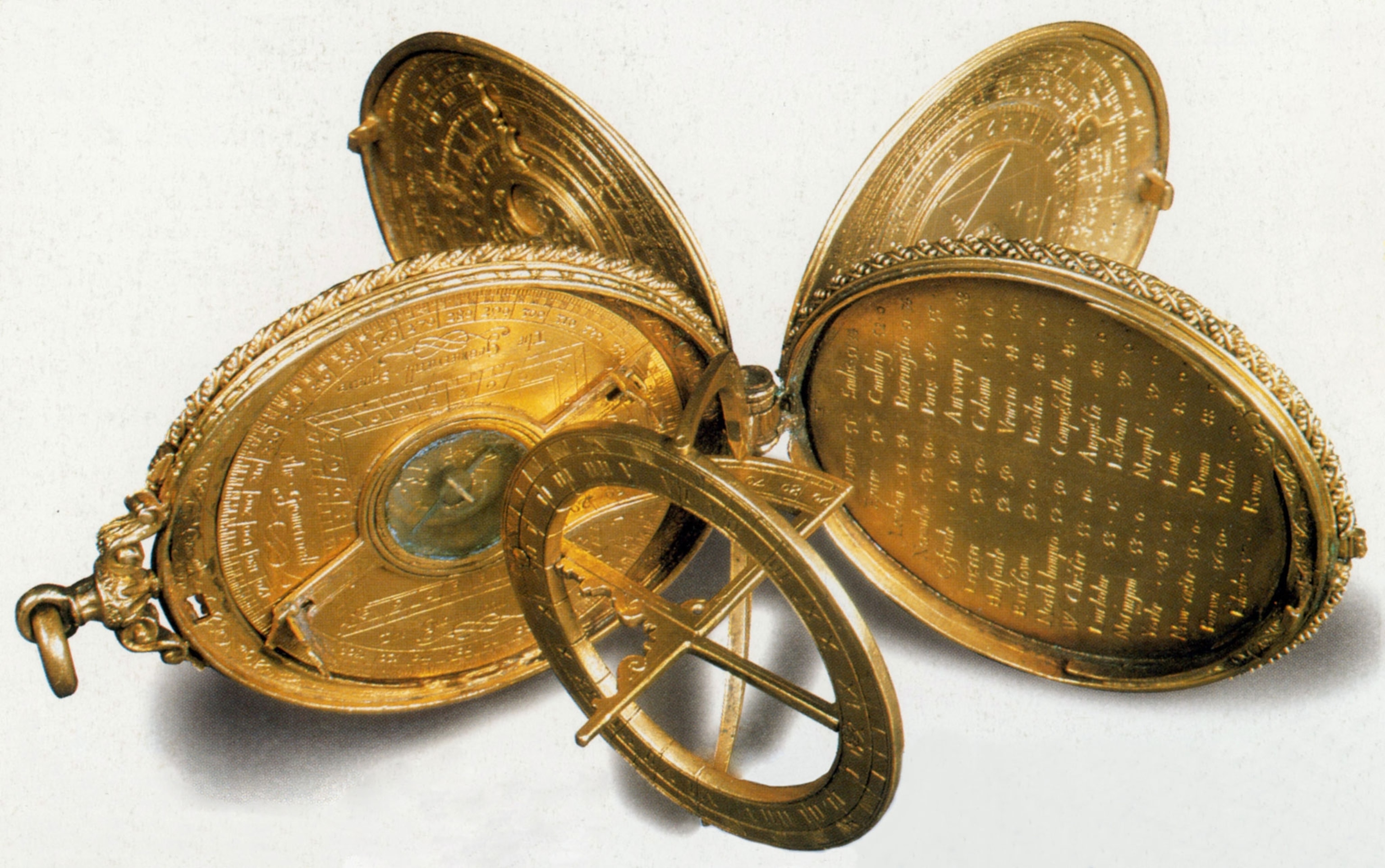 A gold, round, 5 piece compendium made up of a number of different scientific instruments, with tiny engraved numbers and letters on it, has many uses, including a compass, a perpetual calendar and a geometric square