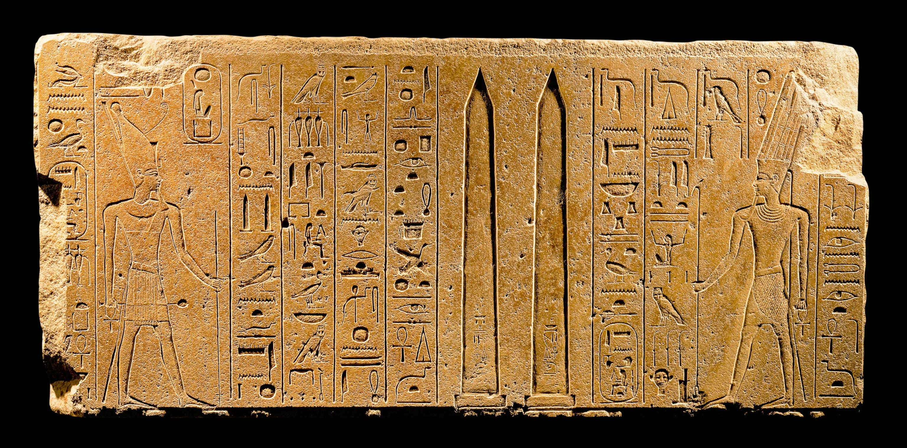 In this stone relief, Queen Hatshepsut offers two obelisks to the god Amun-Re