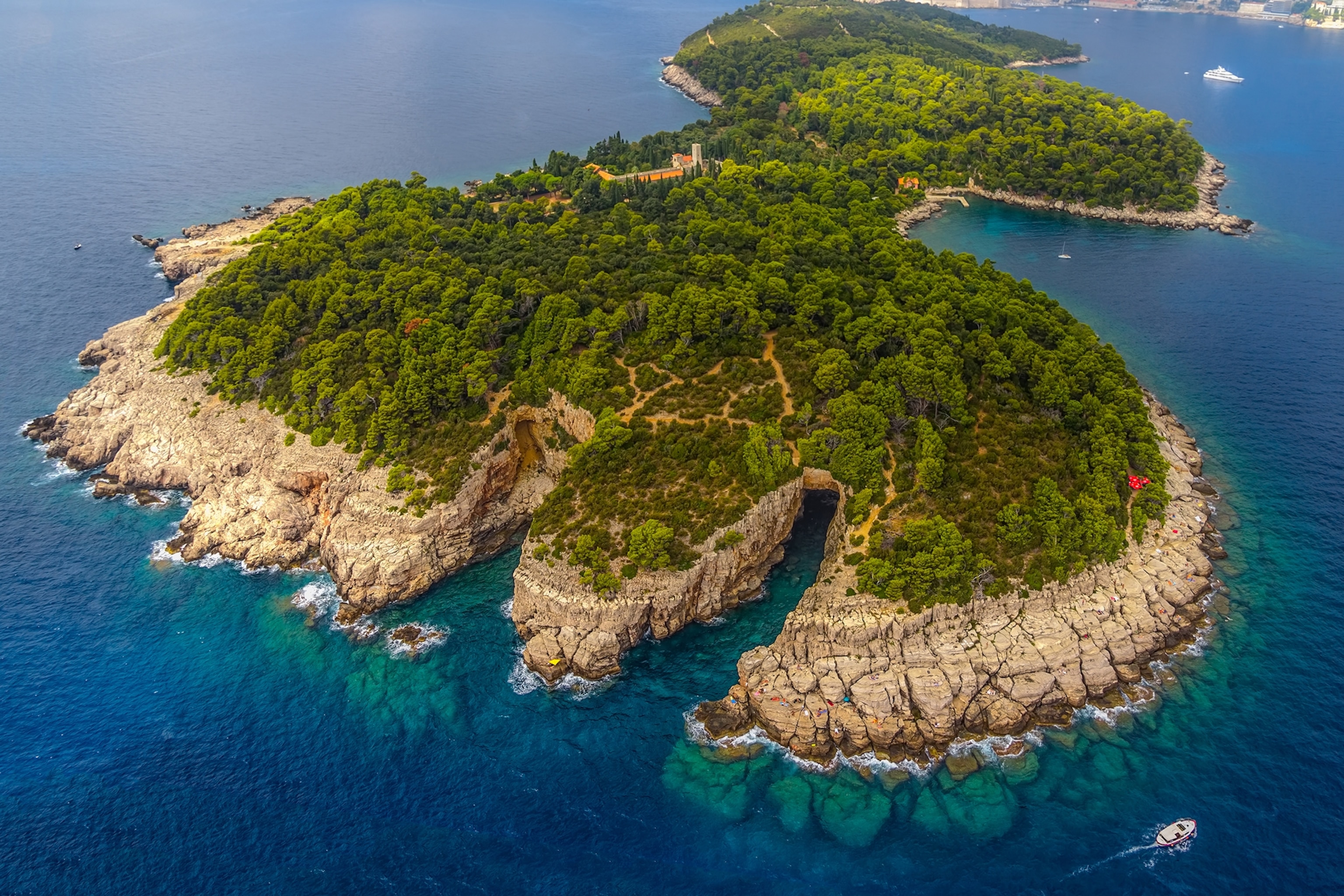 Birds eye view image of a green island surrounded by blue waters