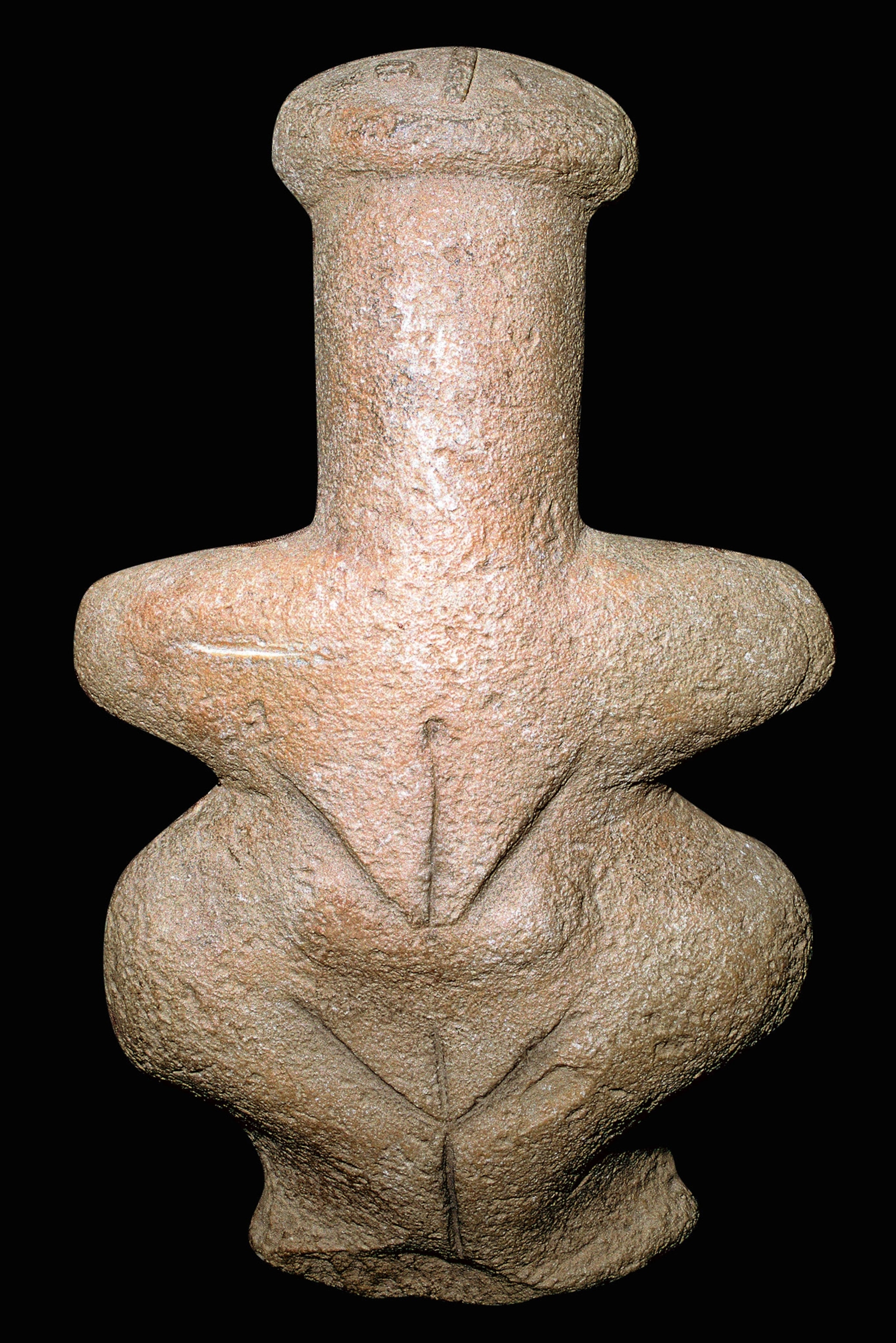 A limestone figure with wide hips and a pregnant belly