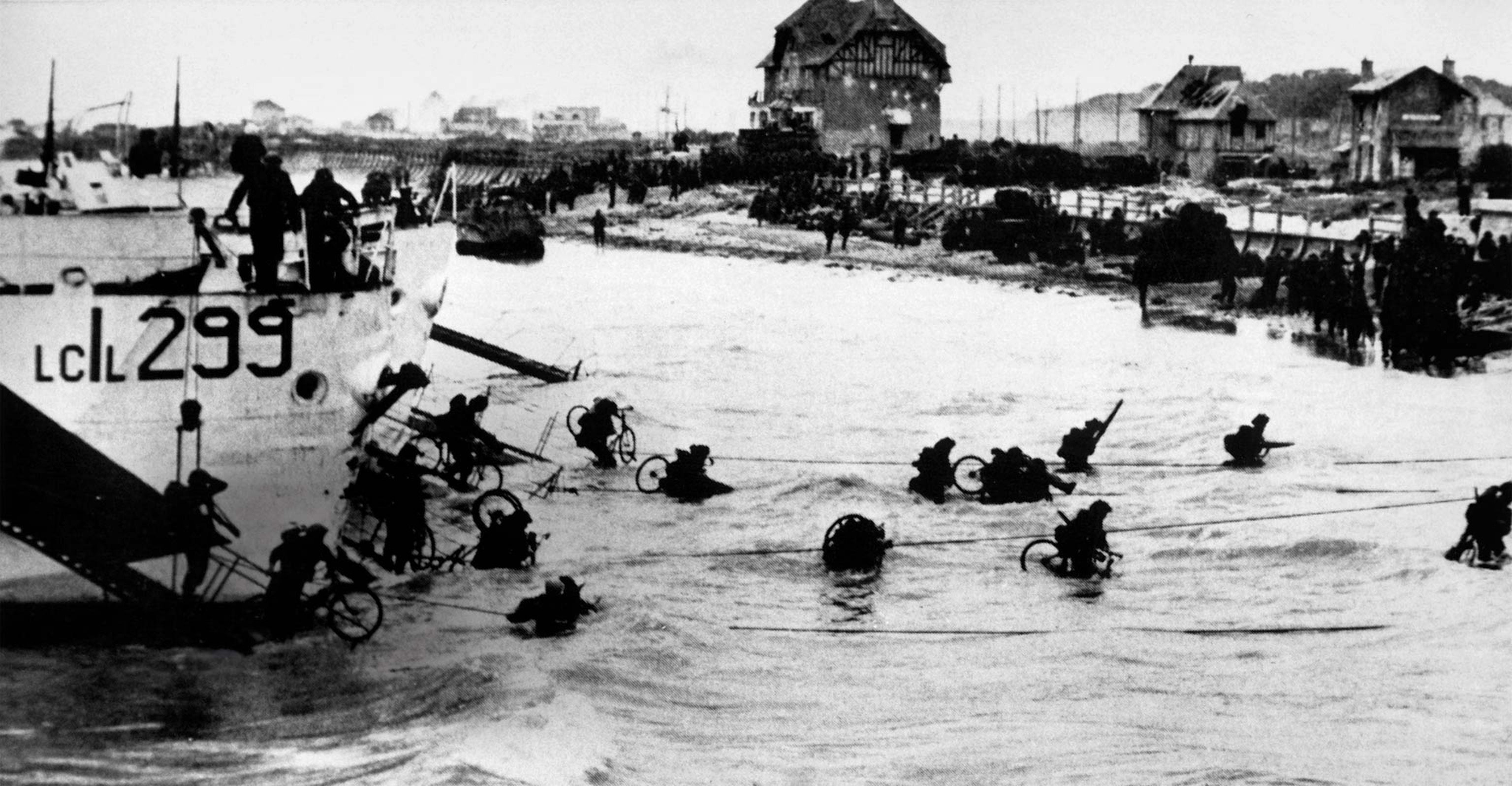 Troops jump off their craft into the waters at Juno Beach in Normandy